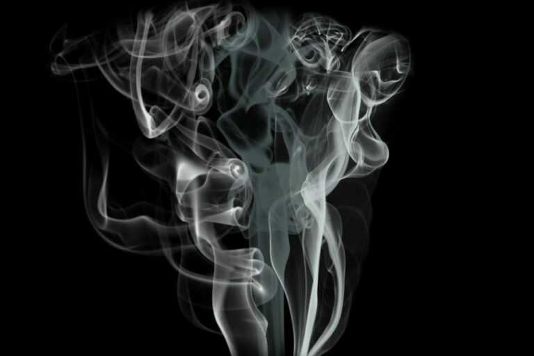 White smoke swirling abstractly against a dark background.